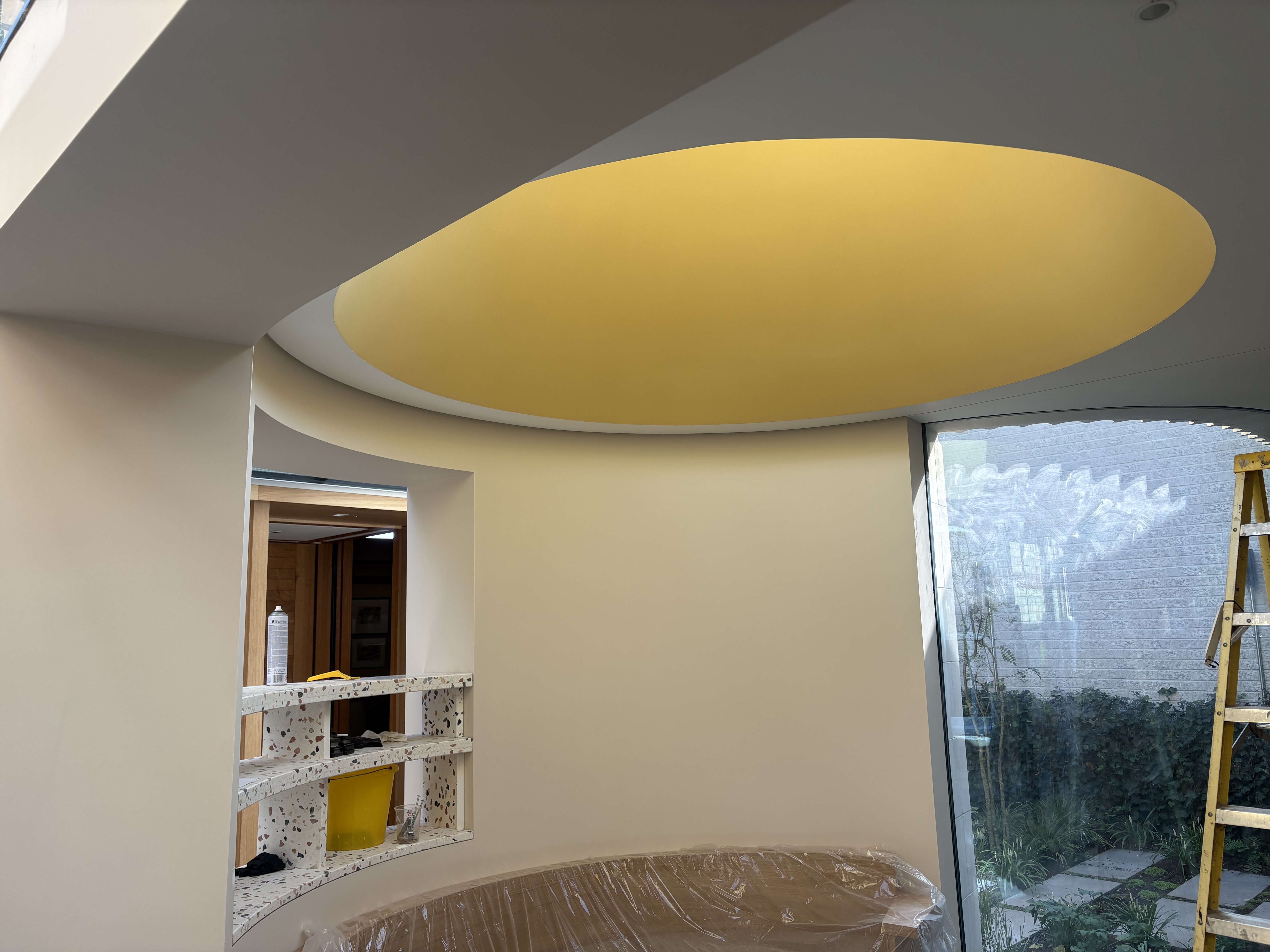 Curved room interior with oval lit ceiling and glass windows