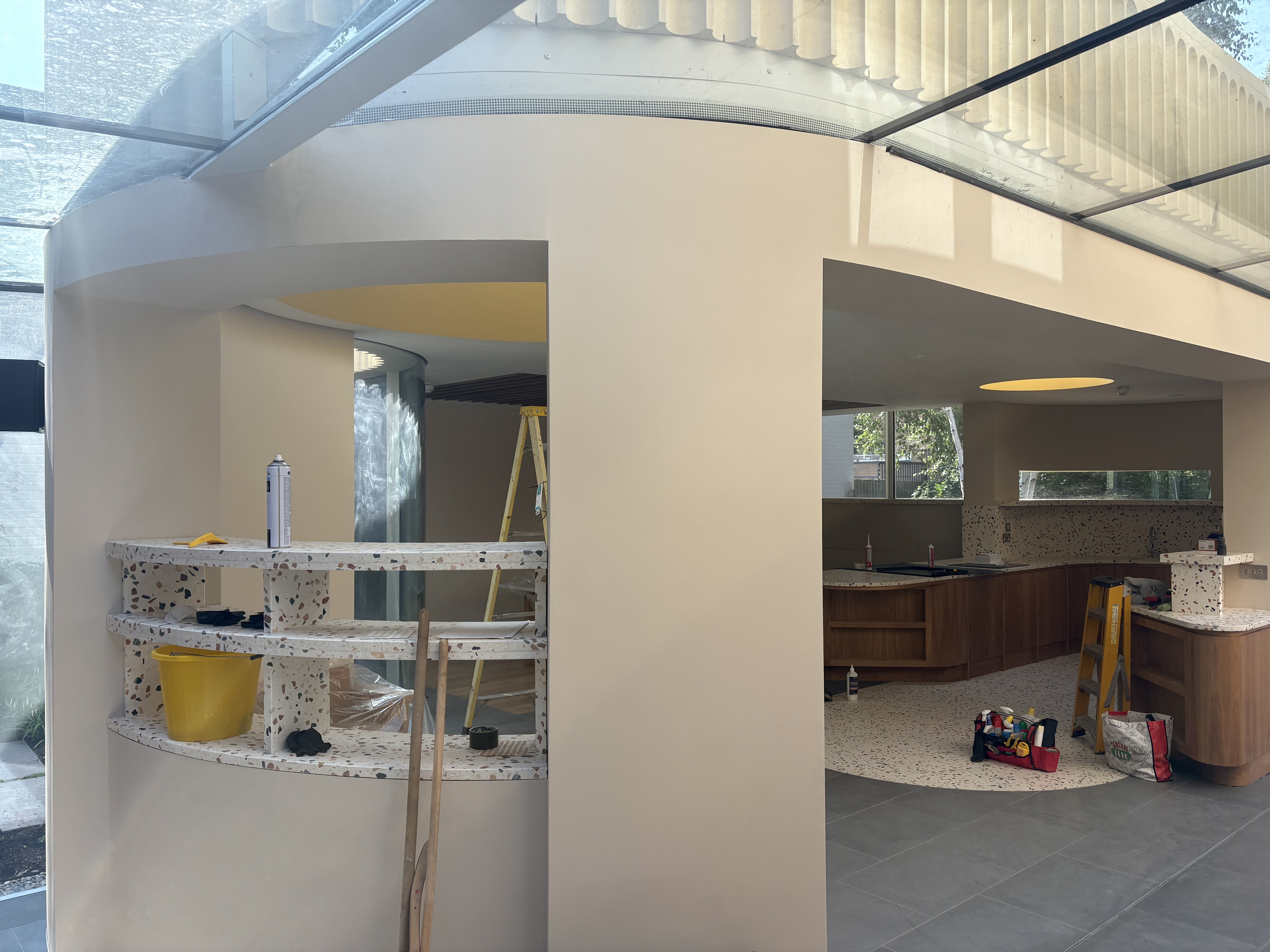 Open plan space with curved walls and modern kitchen area